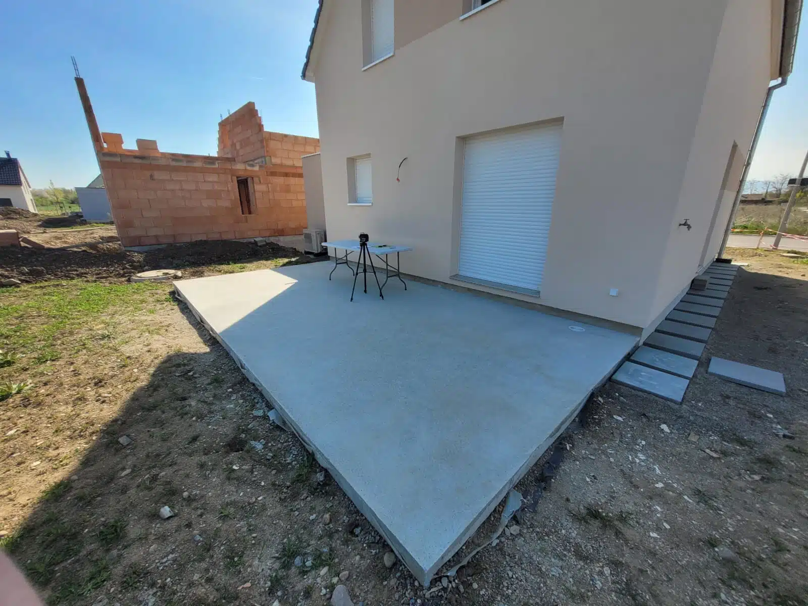 Pergola bioclimatique motorisée en aluminium couleur taupe installée en façade arrière de maison à Meyenheim, vue latérale droite