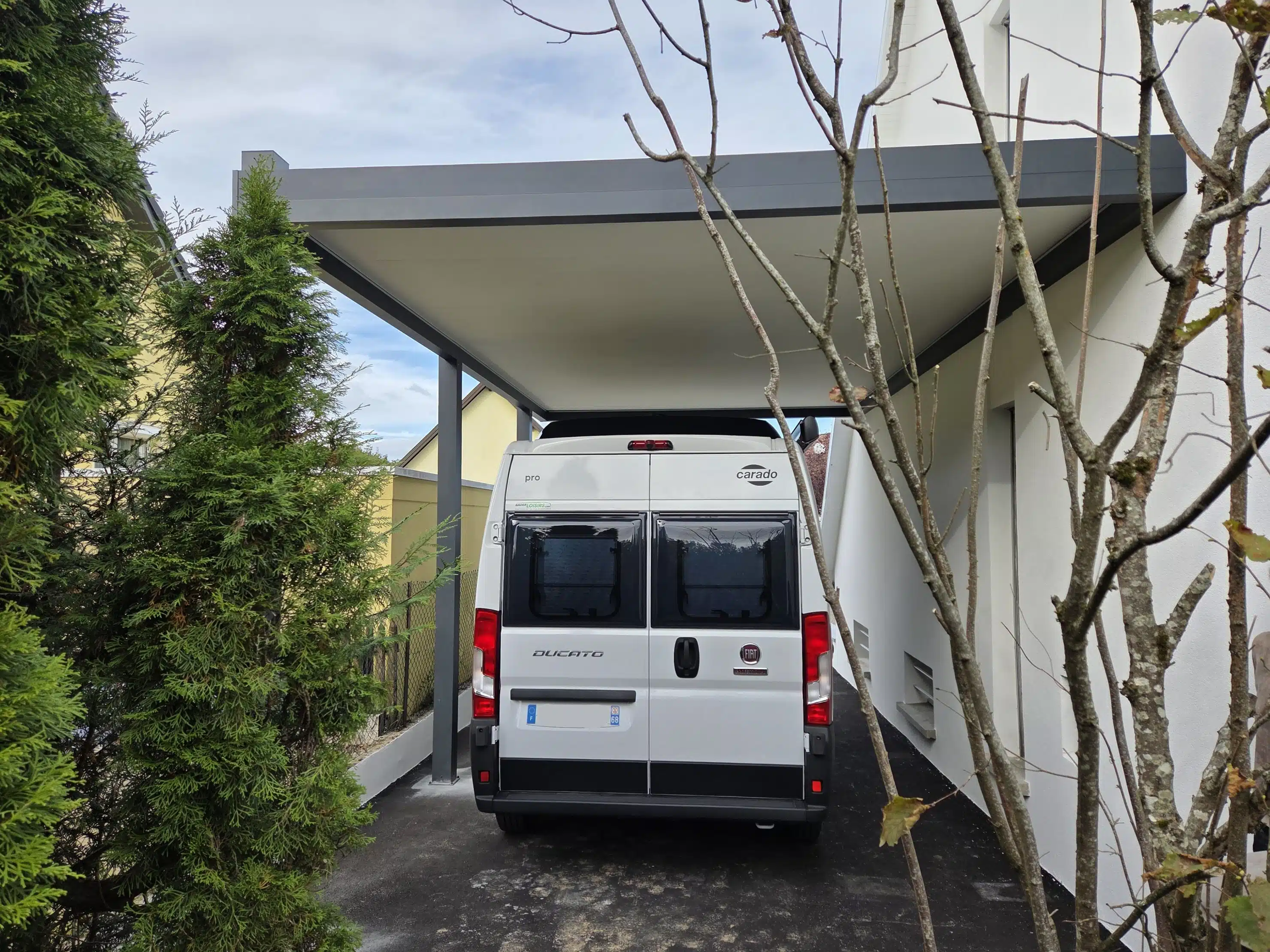 Vue arrière d’un carport camping-car adossé en aluminium avec toiture plate grande dimension à Guewenheim