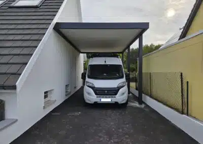 Vue rapprochée de face d’un carport camping-car adossé en aluminium avec toiture plate à Guewenheim