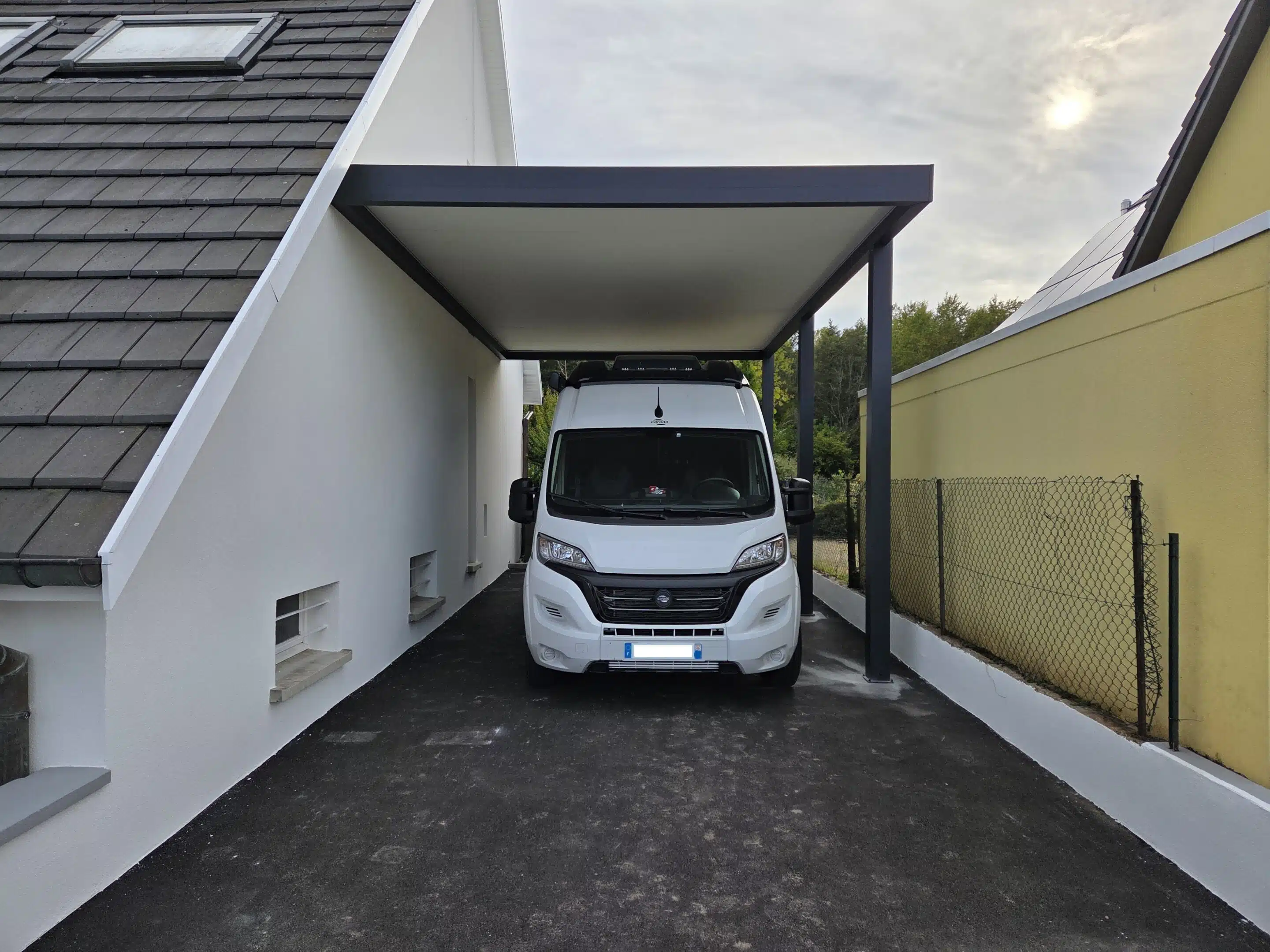 Vue rapprochée de face d’un carport camping-car adossé en aluminium avec toiture plate à Guewenheim