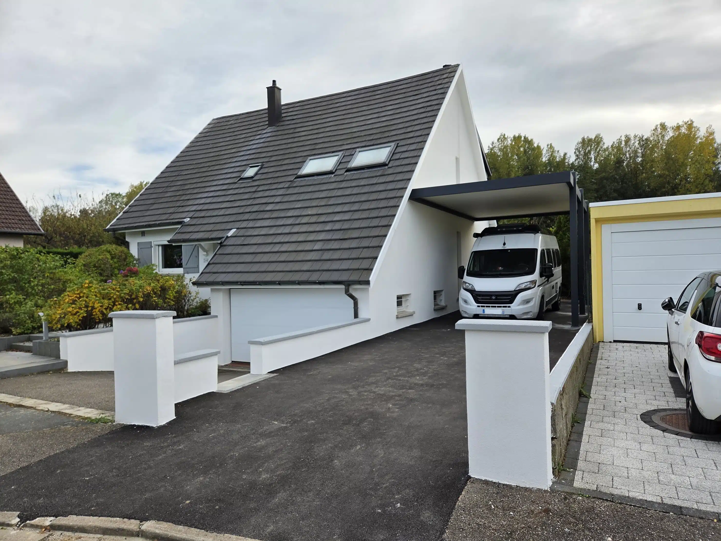 Vue depuis la rue d’un carport camping-car adossé en aluminium avec toiture plate à Guewenheim