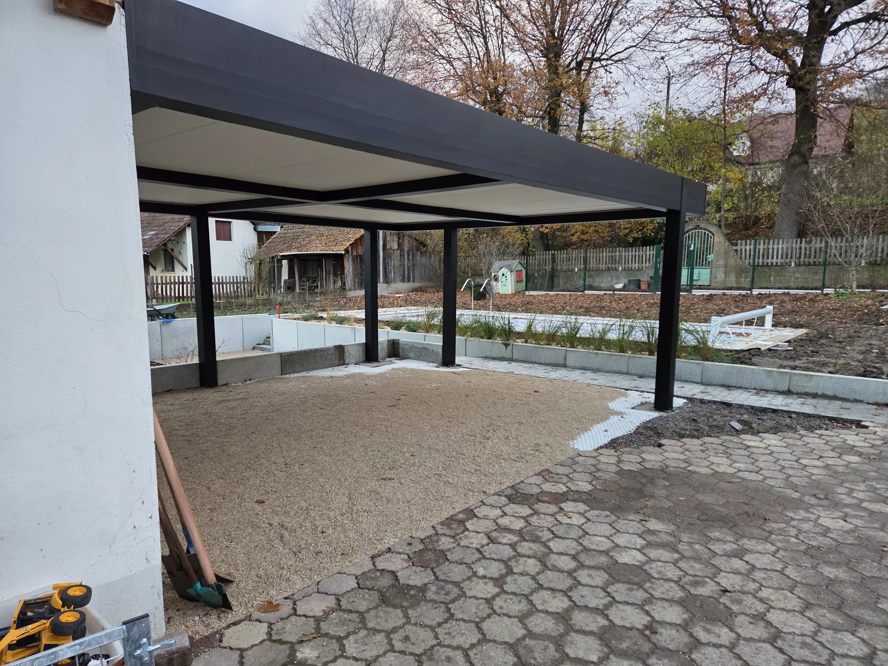 Carport double en aluminium adossé avec poteaux déportés à Muespach, vue en biais, toiture plate sur mesure