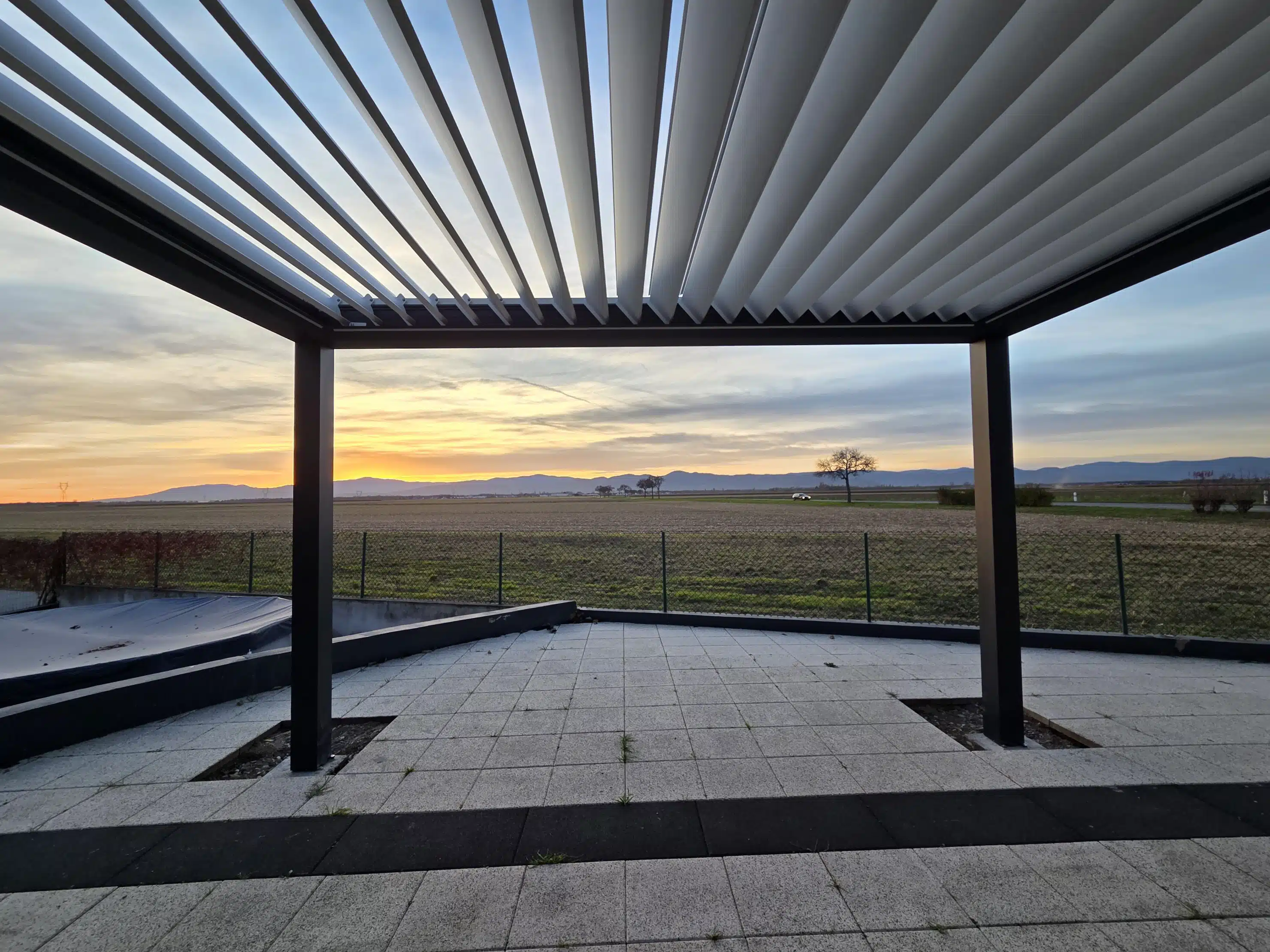 Pergola bioclimatique motorisée avec lames orientables vue du dessous permettant la gestion de la lumière naturelle à Appenwihr