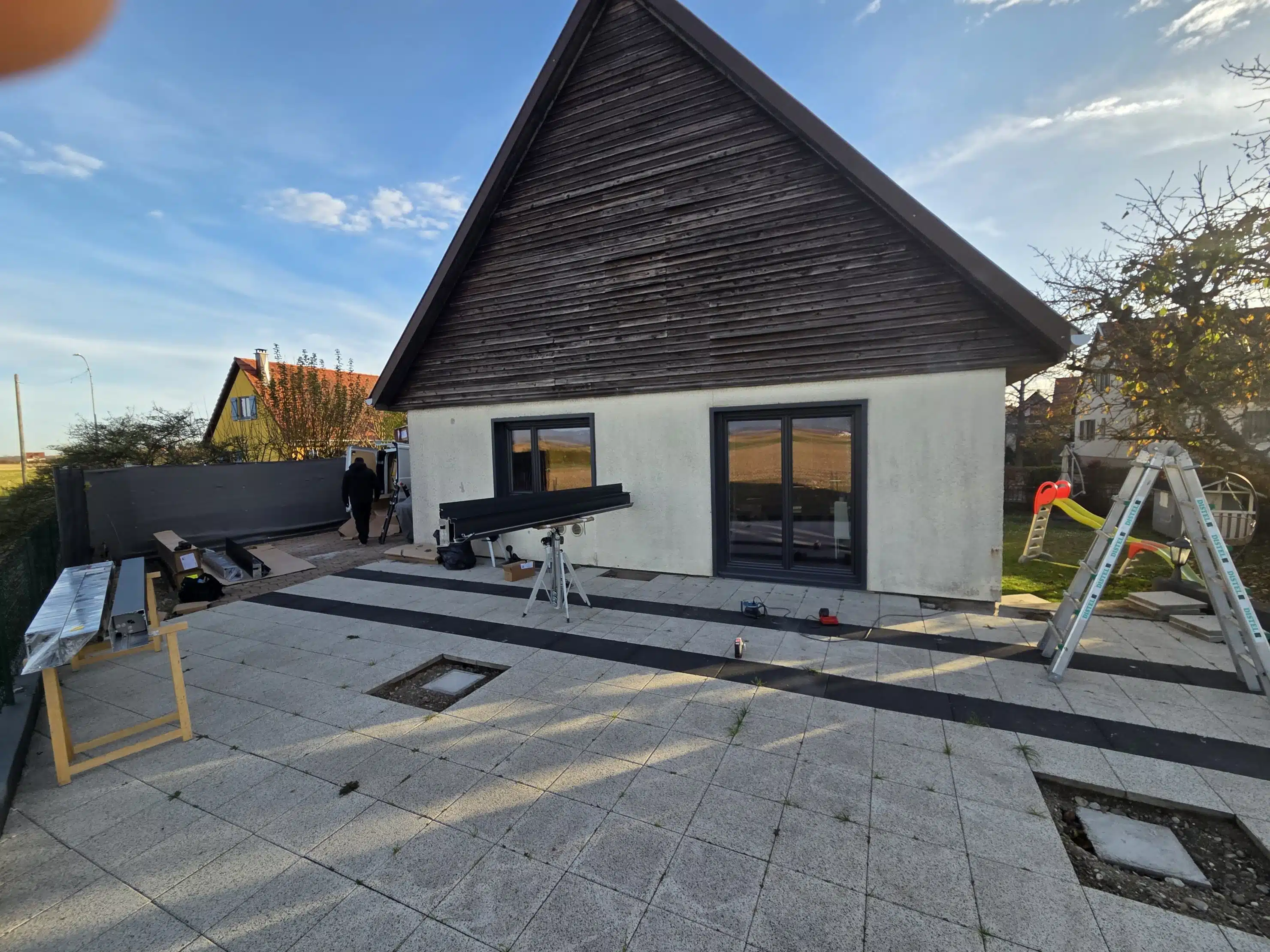 Début du montage d’une pergola bioclimatique motorisée en aluminium sur une terrasse existante à Appenwihr
