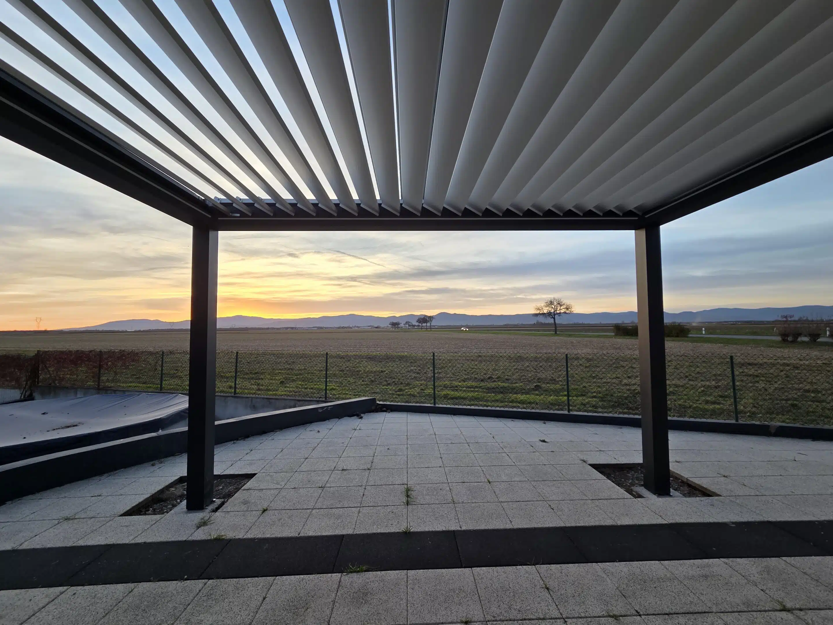 Lames partiellement ouvertes sur pergola bioclimatique motorisée pour un équilibre ombre et lumière à Appenwihr