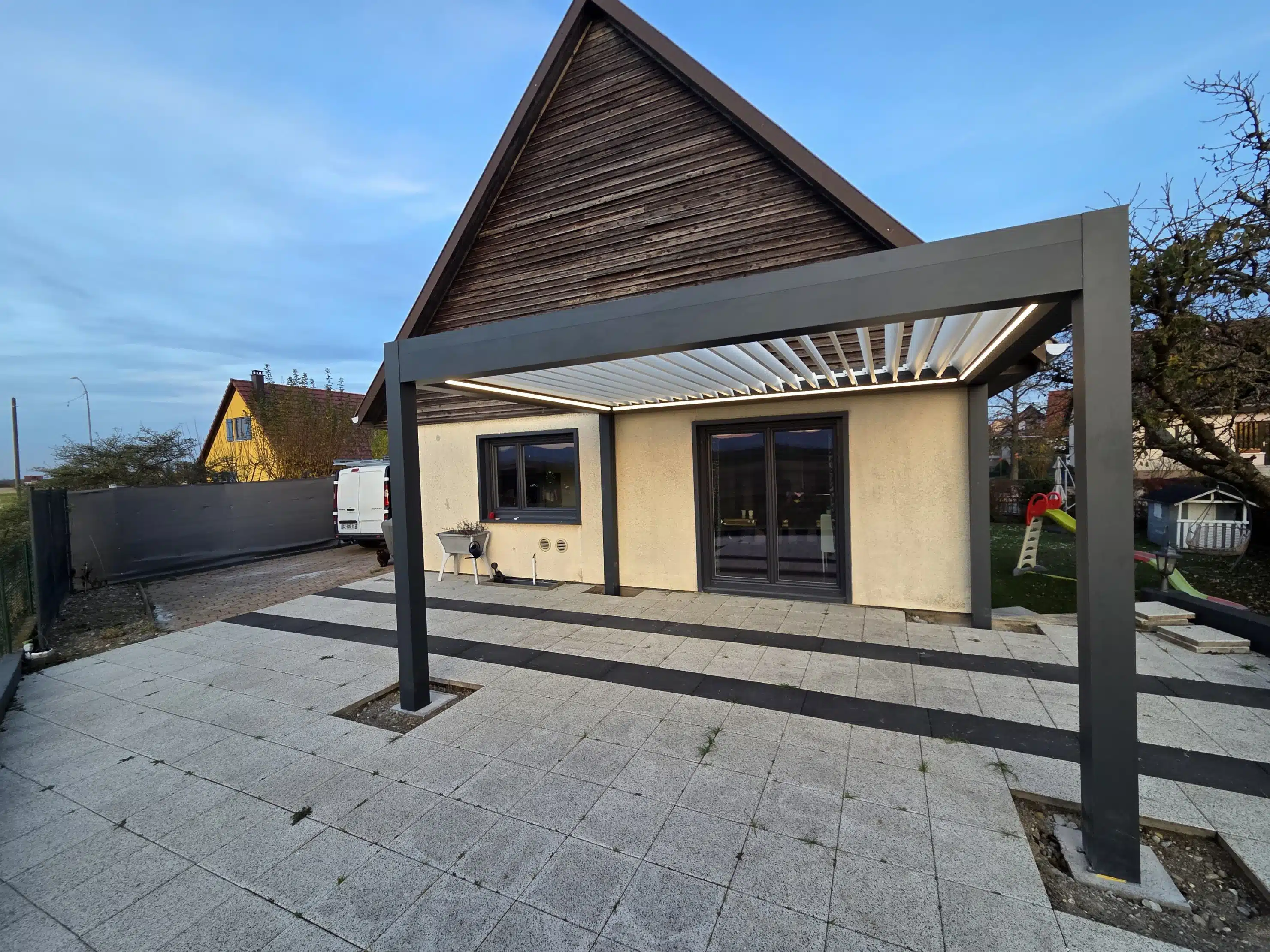 Pergola bioclimatique motorisée avec éclairage LED allumé créant une ambiance chaleureuse à Appenwihr