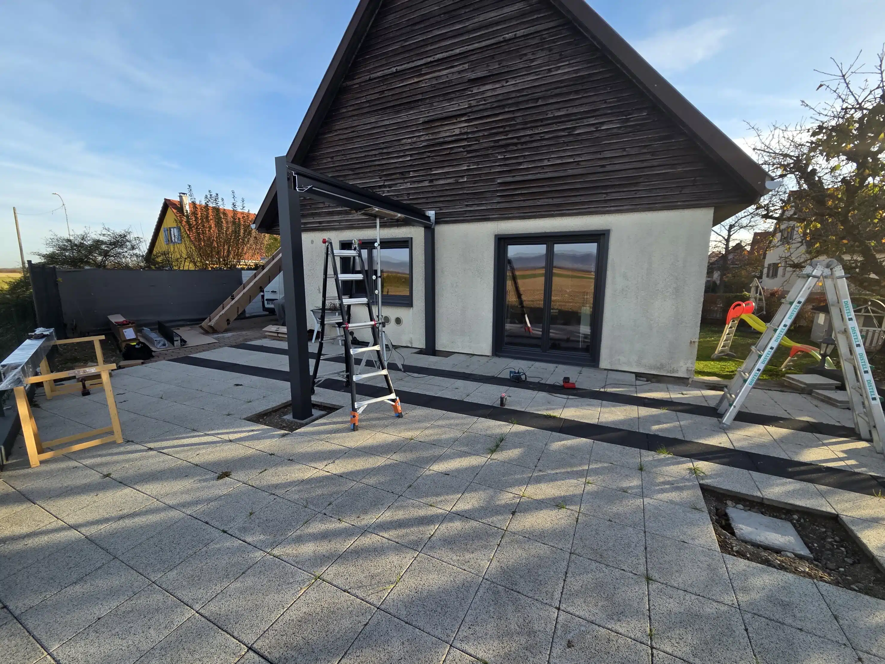 Montage du premier côté d’une pergola bioclimatique motorisée en aluminium sur mesure à Appenwihr