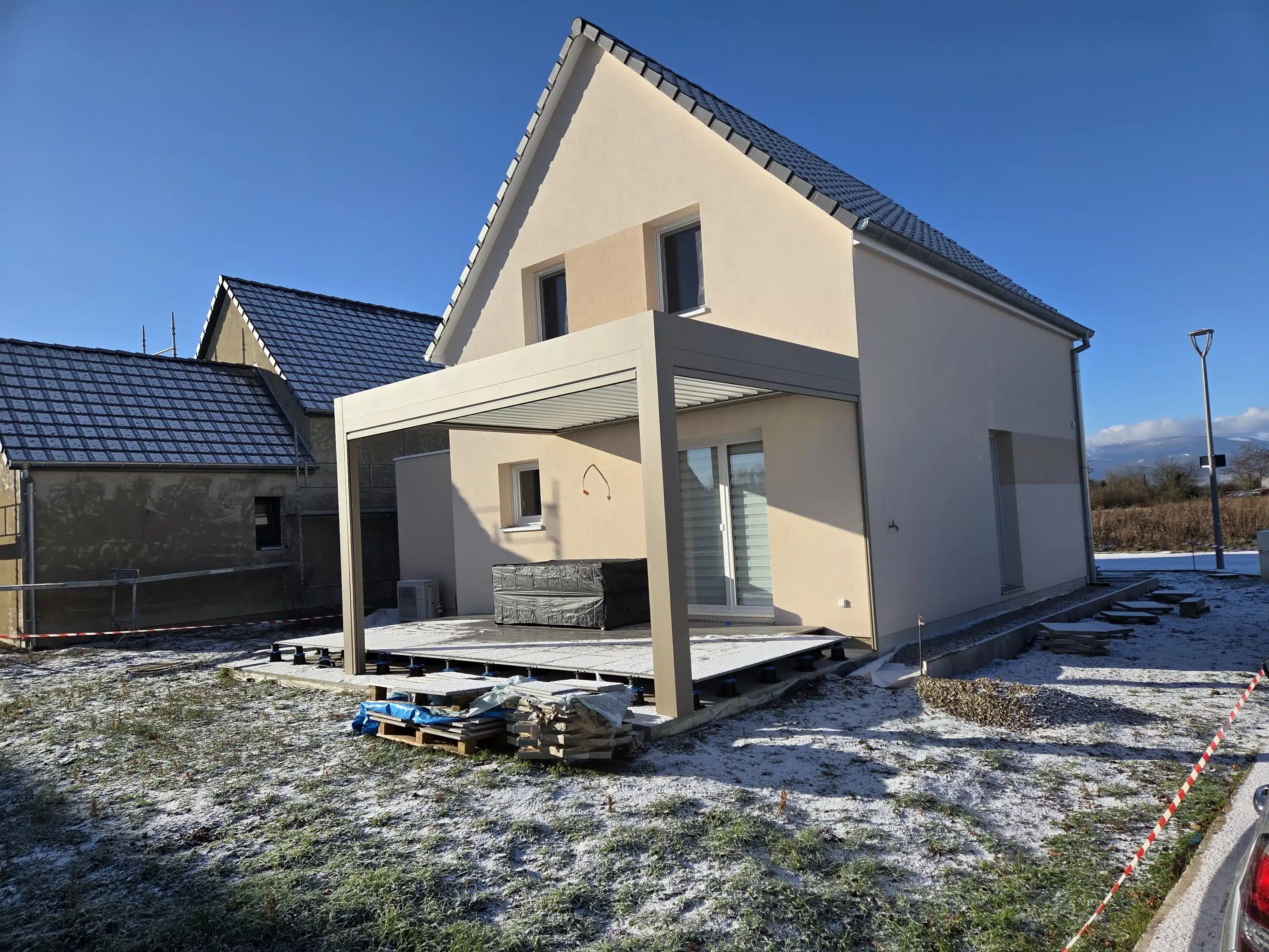Pergola bioclimatique motorisée en aluminium couleur taupe avec stores ZIP installée à Meyenheim, vue depuis la rue