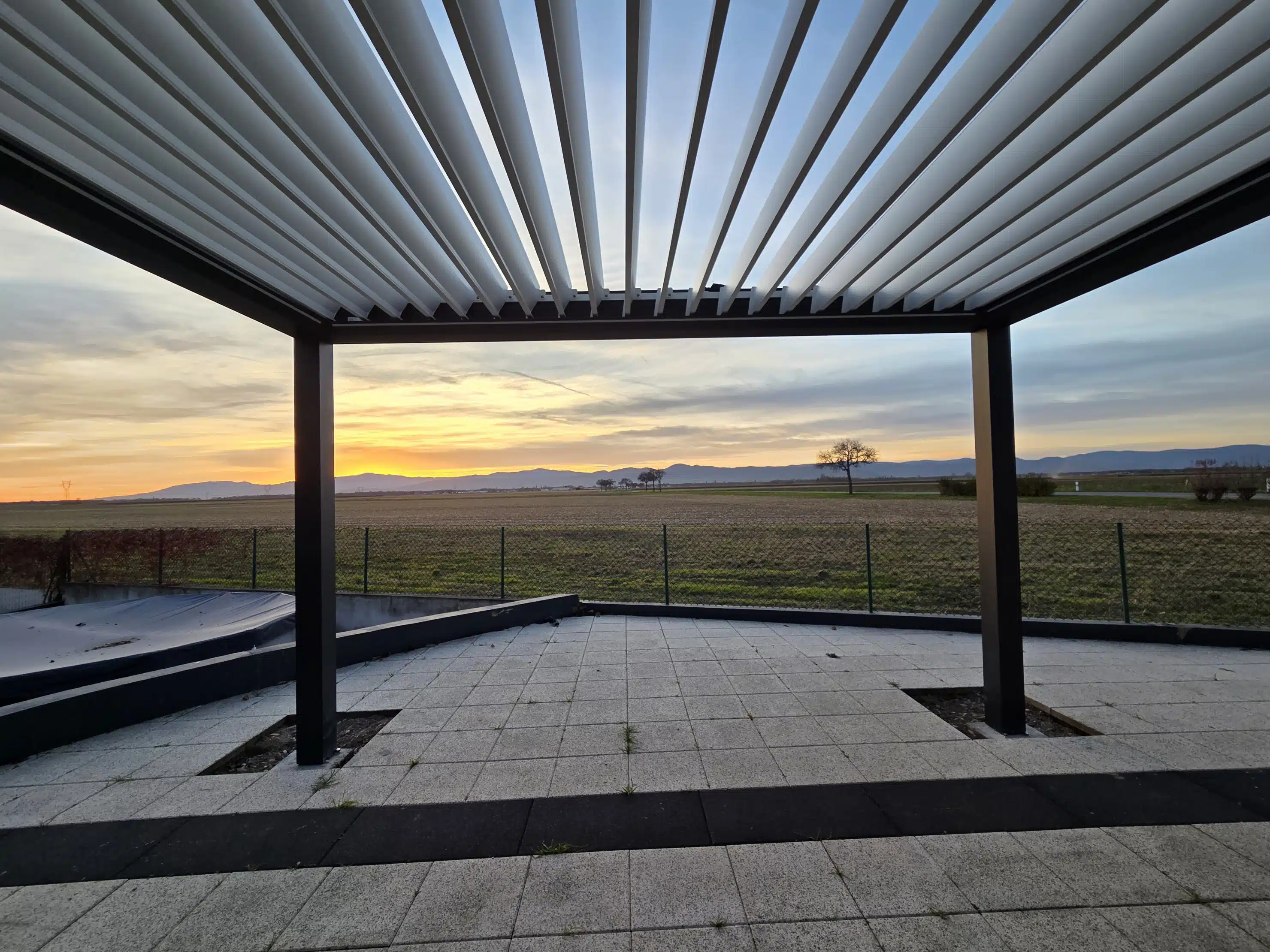 Pergola bioclimatique motorisée sur mesure au coucher de soleil à Appenwihr