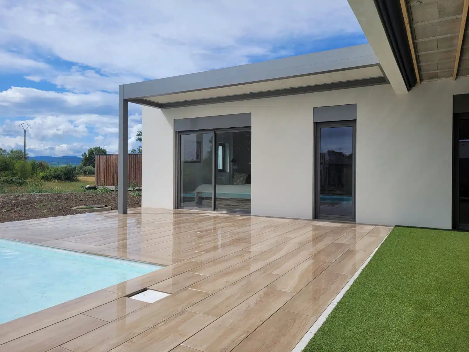 Pergola aluminium sur mesure gris clair avec toiture isolée vue en biais à Issenheim dans le Haut-Rhin